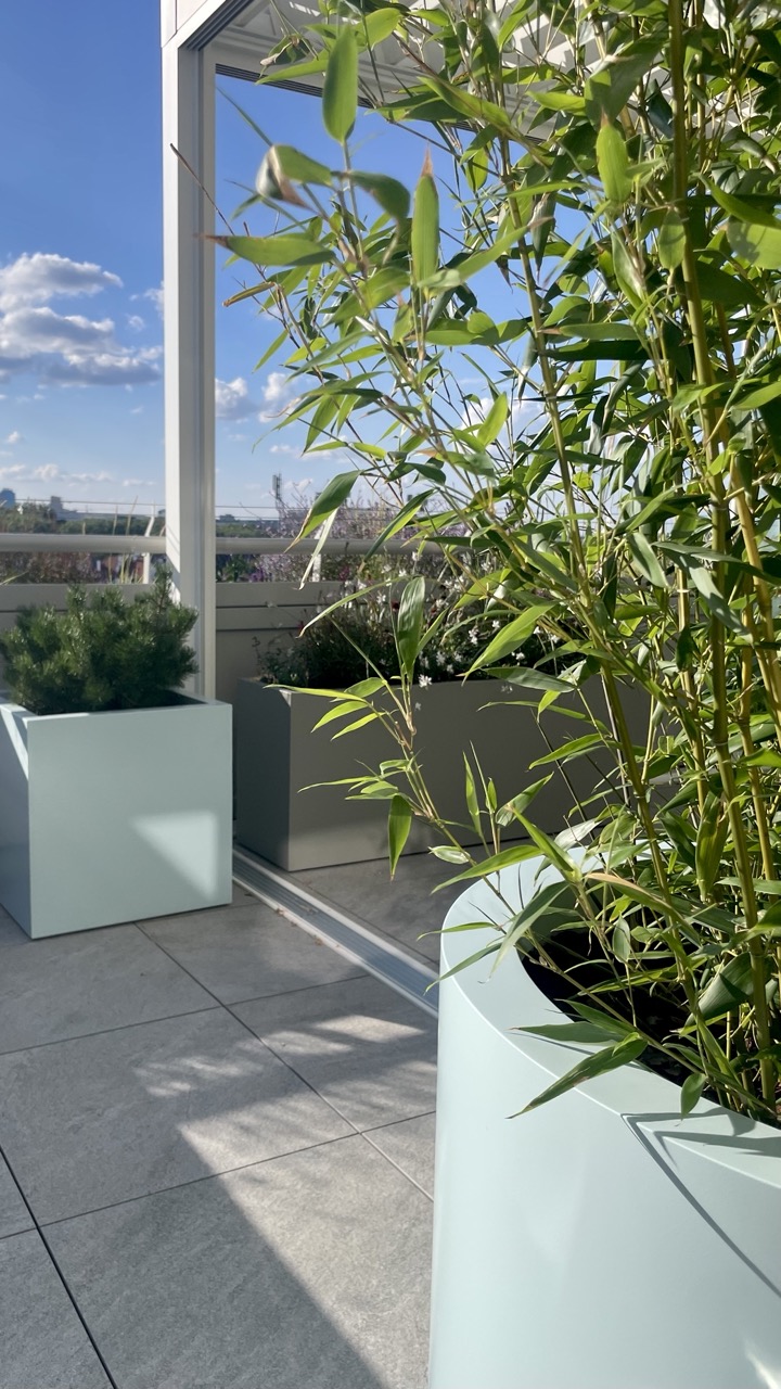 Projekt zagospodarowania tarasu na dziesiątym piętrze. Projekt tarasu z naturalistyczną, lekką kompozycją roślin. Projekt donic aluminiowych w różnych kształtach. Aluminiowe donice na tarasie.